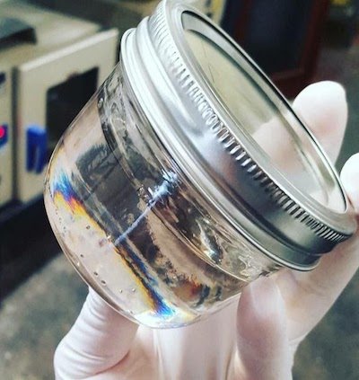 Delta-8 Legal THC clear jar full of tested distillate in hand